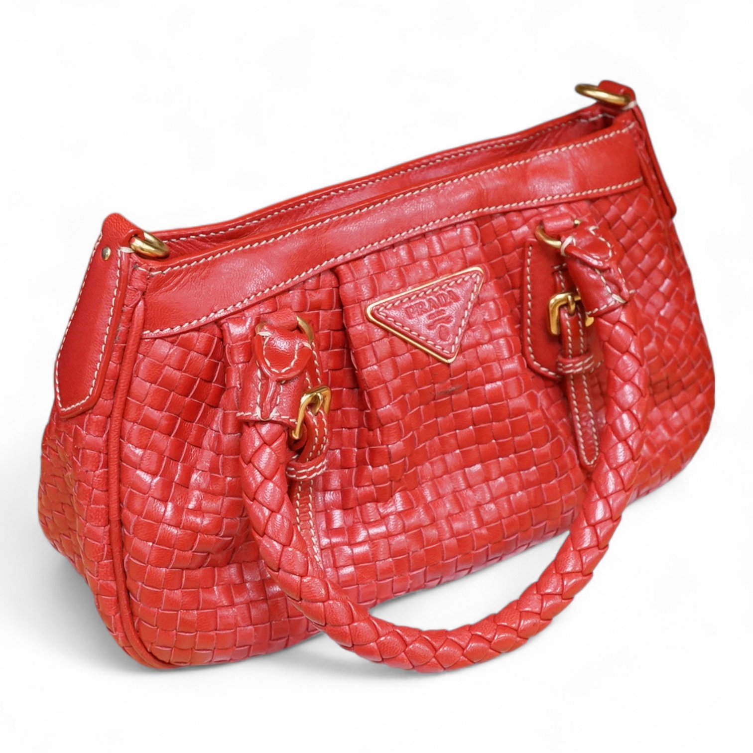 A Prada red braided leather handbag with shoulder strap, authenticity card and dust cover, 25cm wide, Provenance: Purchased by the vendor in Selfridges